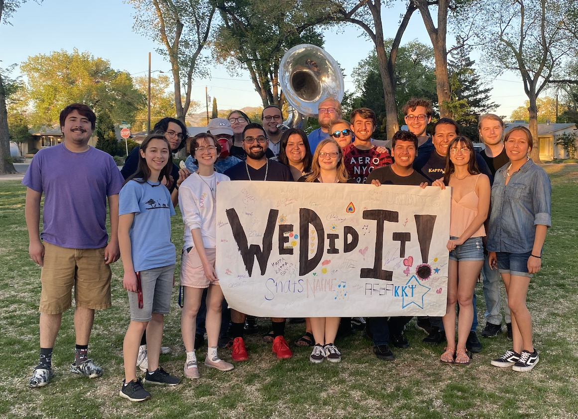 NAfME Members at a park holding a sign that reads "We Did It!"